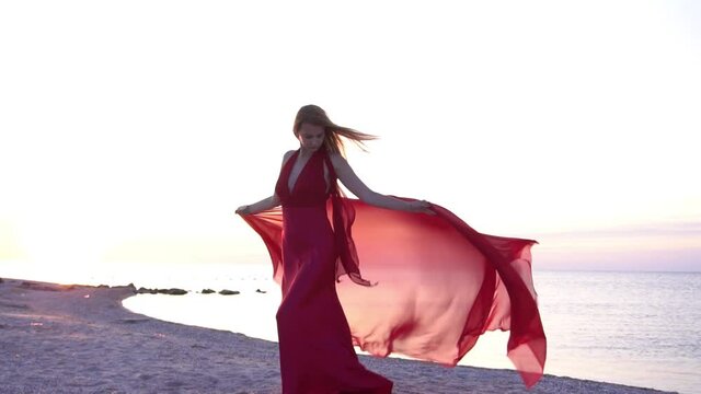 Beautiful girl in flying Red Dress with long train, Model with Gown Levitating 