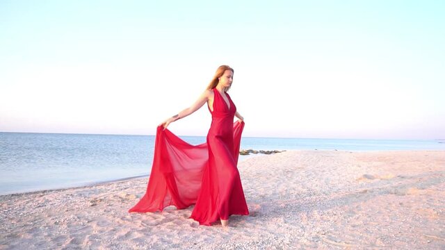Slow Motion Sexy young woman in long red dress flying under wind