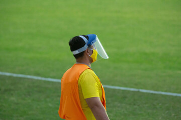 Jogo de futebol brasileiro camisa azul e listrada. Bandeirinha com bandeira listra e gandula.

