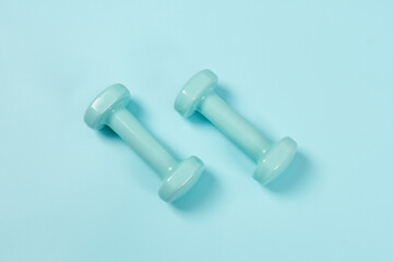 Two blue dumbbells isolated on blue background