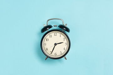 black alarm clock isolated on blue background