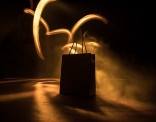 Brown shopping bag with handles placed on dark desktop. Shopping concept