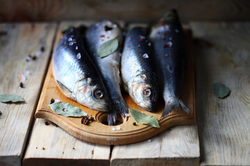Herring with spices on a wooden board.