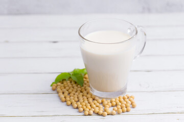 Soy milk and Soybeans on wooden table background. Healthy food Concept.