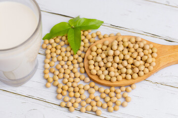 Soy and soy milk in a glass with soybeans in wooden bowl background