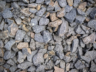Stone background. Crushed stone. Grey stones. Granite macadam. Industrial background. Construction theme. Stone wall texture.