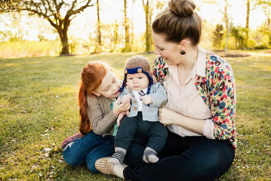 Mid adult mother, daughter and baby son in park