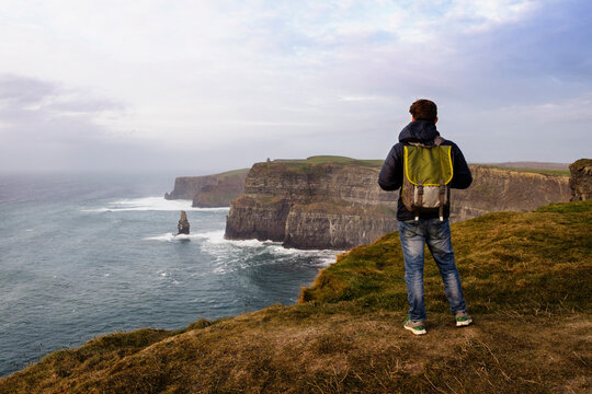 Mid adult man standing on The Cliffs of Moher, The Burren, County Clare, Ireland