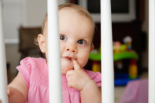 Baby Girl, Looking Through Bars On Cot