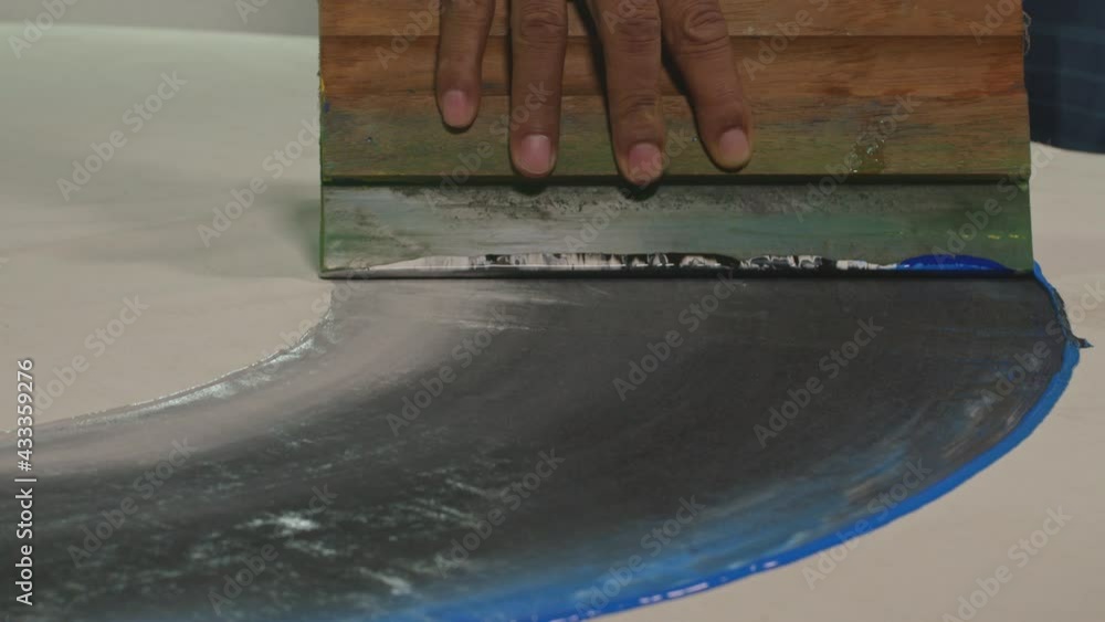 Poster use a squeegee to wipe the paint onto the surface of the material.dark blue shade background..high q