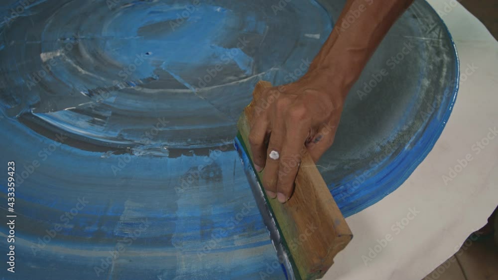 Poster use a squeegee to wipe the paint onto the surface of the material.dark blue shade background..high q