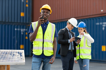 African factory worker or engineer using walkie talkie for preparing a job in containers warehouse storage