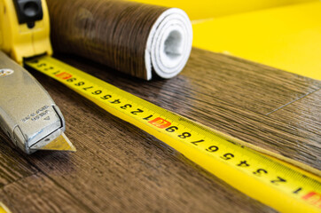 Linoleum tape measure and knife on an isolated background.
