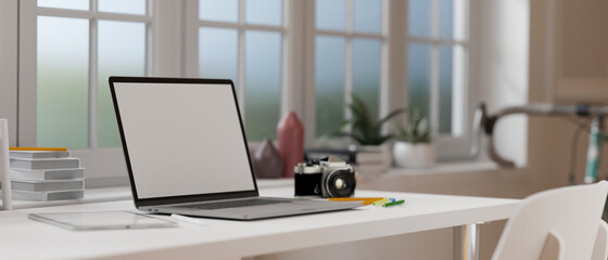 3D rendering, laptop with mock-up screen on white desk with camera, books and supplies in home office room