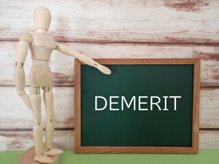 黒板にDEMERITの単語と人形