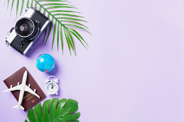 Fototapeta na wymiar Top view flat lay mockup of retro camera films, airplane, passport, world and traveler accessories isolated on a purple background with copy space, Business trip, and vacation summer travel concept