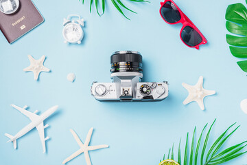 Fototapeta na wymiar Flat lay top view mockup retro camera films, airplane, passport, starfish, shells traveler tropical accessories on a blue background with copy space, Vacation summer travel and business trip concept