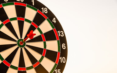 Closeup the dart arrow hit center on Bullseye(bull's-eye) of a dartboard is a target of challenge business, strategy marketing target, objective financial and goal a concept