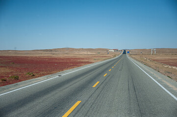Fototapeta na wymiar the long rural road in the desert area