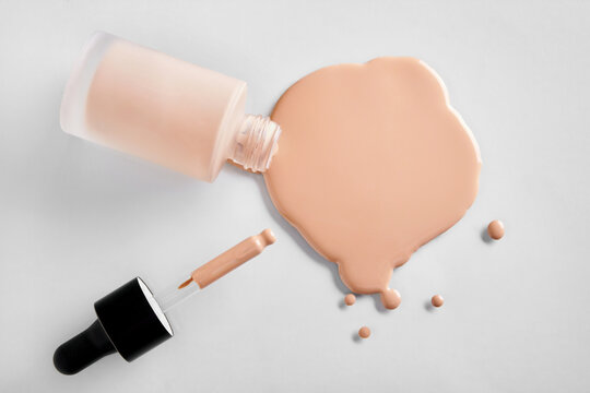 Mockup glass bottle of correction cosmetic product with pipette. Spilled Liquid foundation. Beauty branding concept