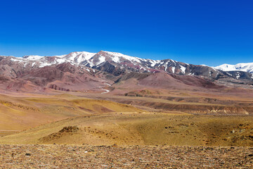 Colorful Mountains of Kyzyl-Chin and top of mountains covered snow, beautiful colored landscape in Altai Republic, Russia. Nature environment landmark.