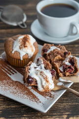 Sweet cherry muffin with ice cream and white cup with tea on a wooden background