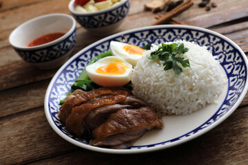 Local Thai food stewed pork leg on rice isolated in wood background