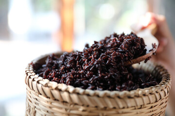 Boiled riceberry rice on wood basket with spoon in close up