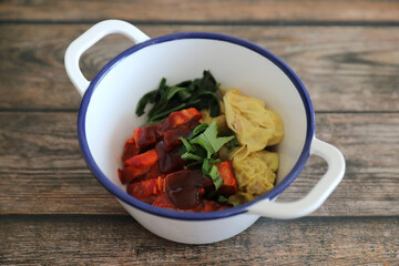 Shrimp dumpling with roasted pork on wood background