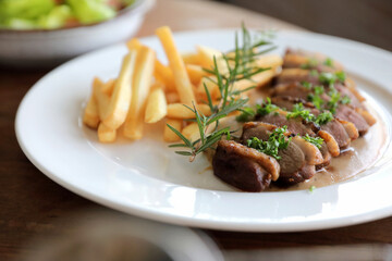 Duck magret confit with chips on wood table