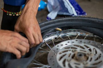 A close-up of the wheels of a motorbike is being removed by a mechanic to recap and change tires...