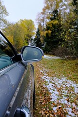 Autumn travel and trips.Road view.First snow. Travel by car. Car on the autumn road.Silver color car on the road with autumn  trees and the first snow. Late fall .