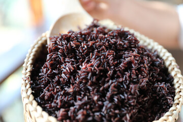 Boiled riceberry rice on wood basket with spoon in close up