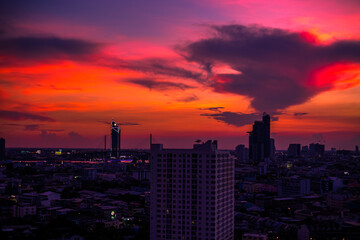 The high angle background of the city view with the secret light of the evening, blurring of night lights, showing the distribution of condominiums, dense homes in the capital community