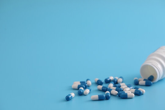 pills capsules with bottle isolated on blue background