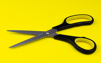 Black and Yellow Open Office Scissors Isolated on Yellow Background, copy Space