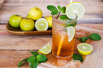 herbal healthy drinks cold lemon tea for health care with peppermint leaf and lemon slice on background wooden
