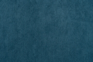 Blue texture of fabric from a textile material for an abstract background for an empty surface and for wall-paper.