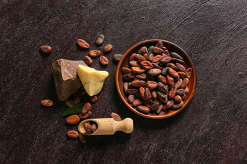 Fototapeta na wymiar Bowl with cocoa beans on dark background