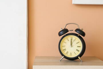 Alarm clock on shelf near color wall