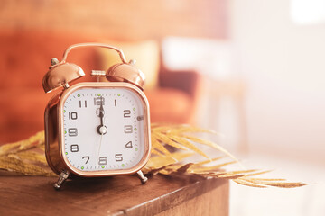 Alarm clock on wooden table in room