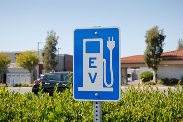 A view of a city sign and symbol for electric vehicle parking and charging.