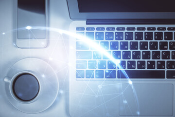 Naklejka premium Social network hologram drawings over computer on the desktop background. Top view. Double exposure.