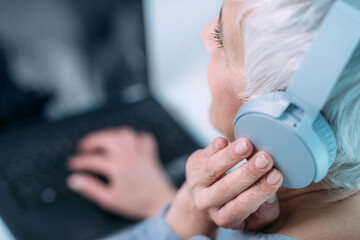Hearing test or audiogram. Senior woman self-testing hearing ability with laptop