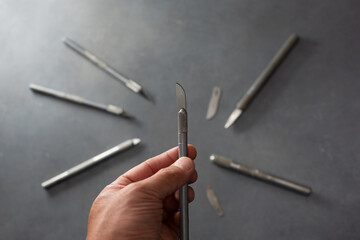 A view of a hand holding a sharp hobby knife.