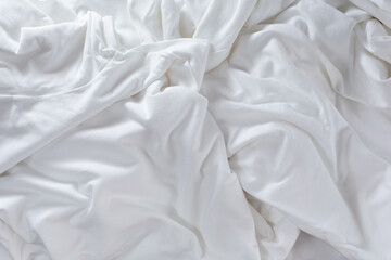 A top down view of a white natural wrinkle and folds cloth, as a background.