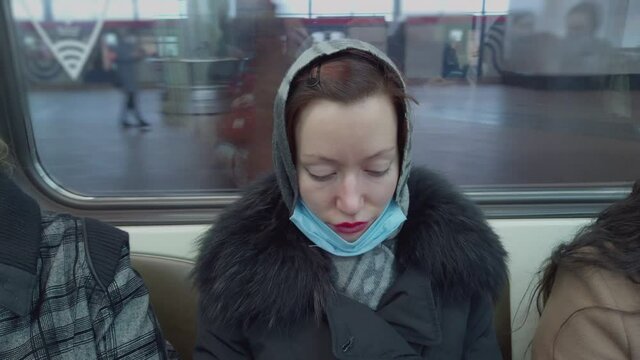 Woman in shawl in metro train reads something interesing