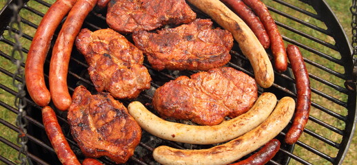 various meat and sausages on the charcoal grill