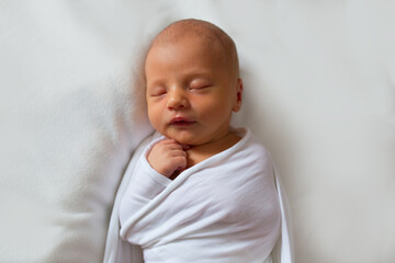 Portrait of a sleeping new born baby boy. Light, soft and clean newborn baby picture.