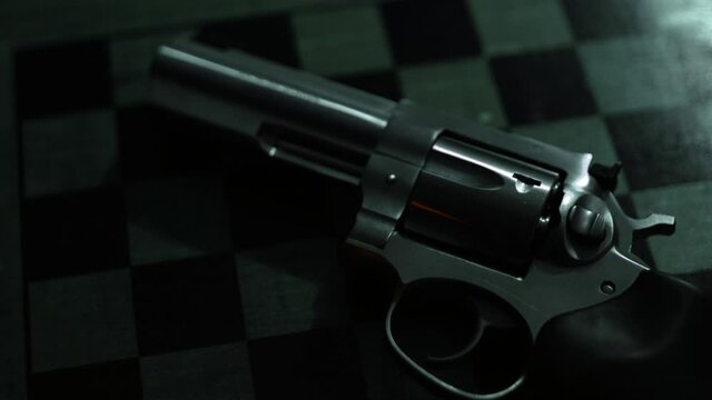 Red Light Flashing Across Stainless Steel .357 Magnum Revolver on Wooden Chessboard